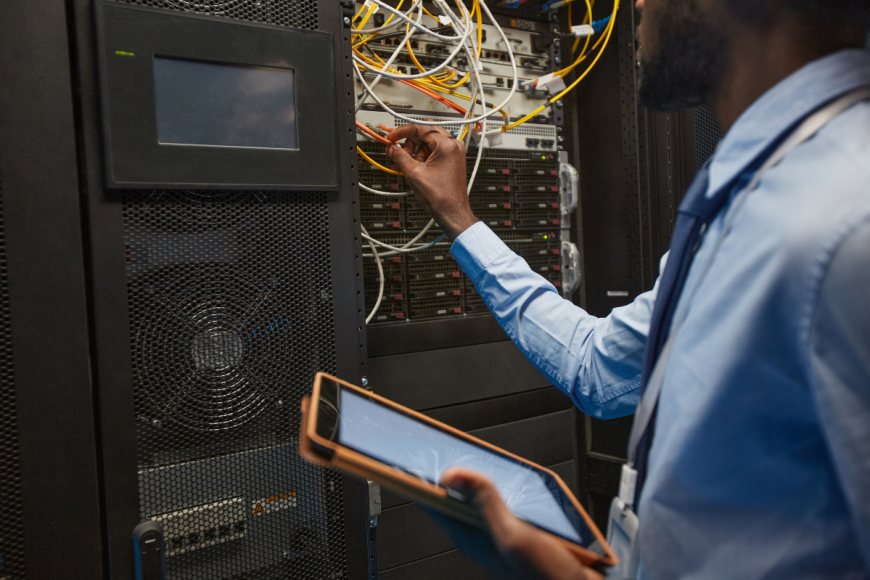 Man connecting servers in data centre