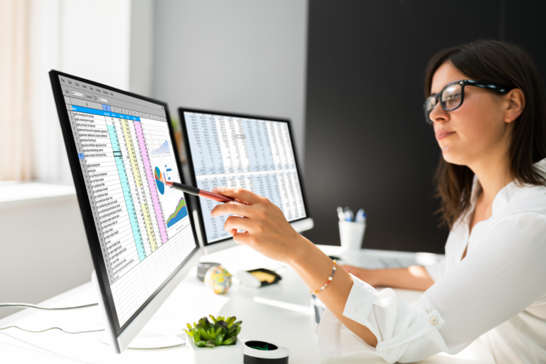 Woman working on computer with 2 screens