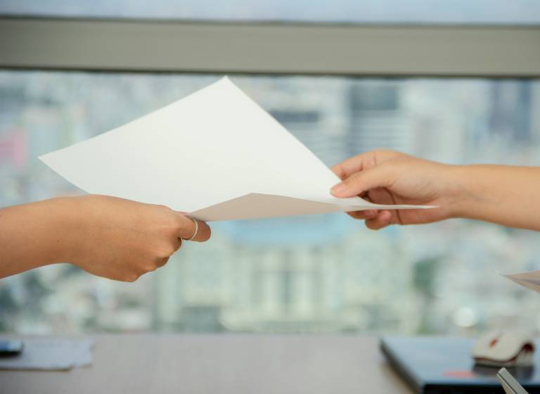 A piece of paper being passed between two individuals