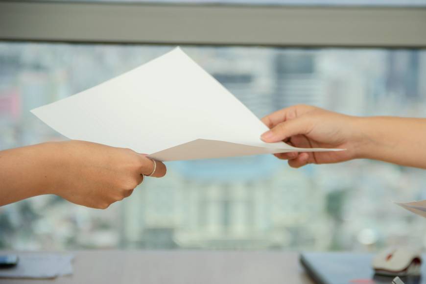 A piece of paper being passed between two individuals